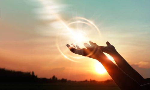 Woman hands praying for blessing from god on sunset background